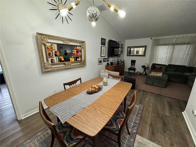 dining space with a textured ceiling, vaulted ceiling, wood finished floors, and a chandelier