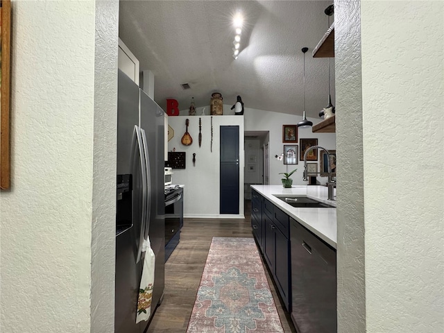 kitchen featuring dark wood-type flooring, dishwasher, light countertops, lofted ceiling, and a sink