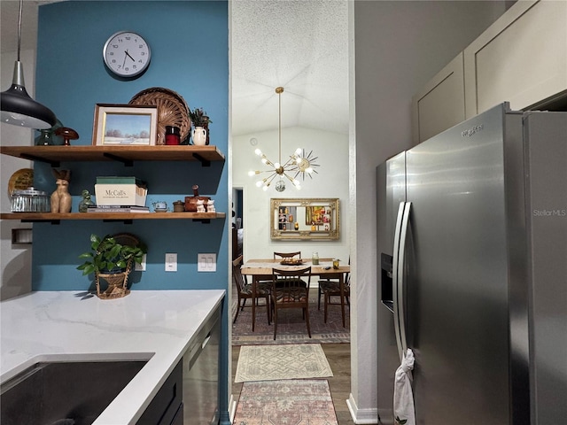 kitchen with light stone counters, wood finished floors, open shelves, stainless steel appliances, and a chandelier