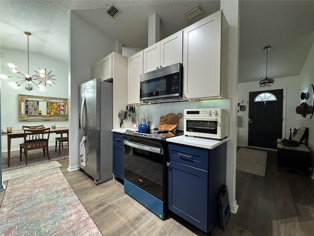 kitchen featuring blue cabinets, visible vents, light wood-style floors, appliances with stainless steel finishes, and an inviting chandelier