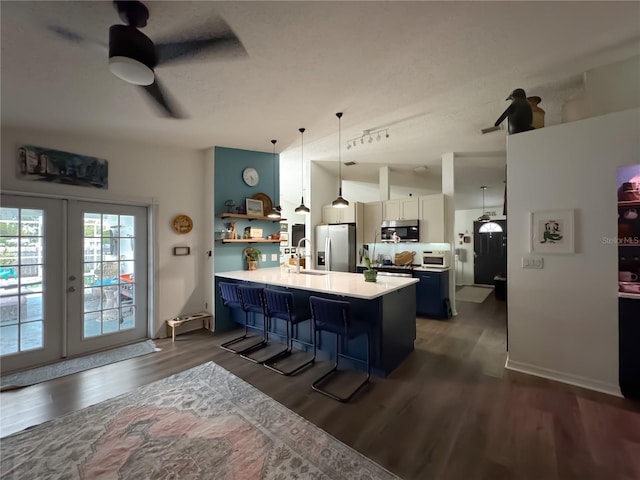 kitchen with a kitchen breakfast bar, dark wood-type flooring, appliances with stainless steel finishes, and light countertops