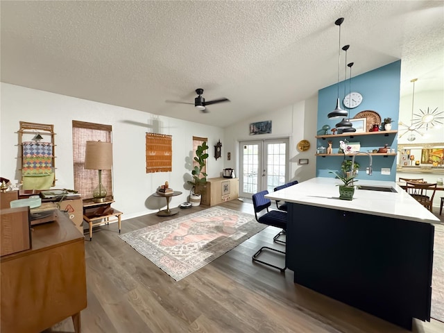 office featuring wood finished floors, ceiling fan, vaulted ceiling, french doors, and a textured ceiling