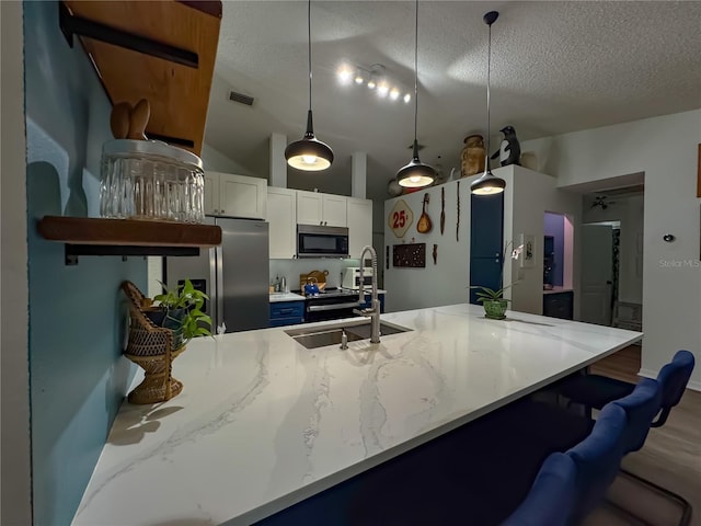 kitchen featuring a sink, stainless steel fridge with ice dispenser, black microwave, and a textured ceiling