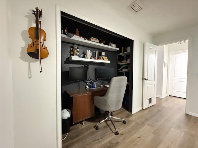 office space with wood finished floors, visible vents, and baseboards