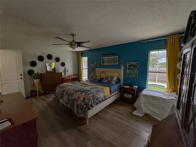 bedroom with ceiling fan, a textured ceiling, and wood finished floors