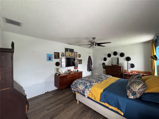 bedroom featuring visible vents, a ceiling fan, a textured ceiling, wood finished floors, and baseboards