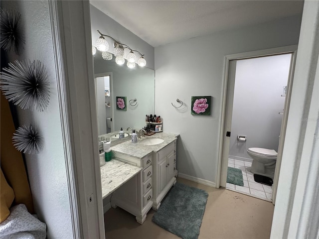 bathroom with vanity, tile patterned floors, toilet, and baseboards