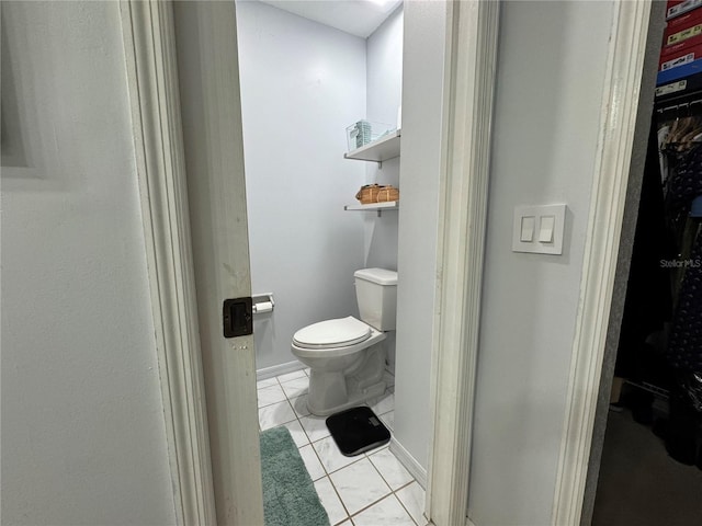 bathroom featuring tile patterned floors, toilet, and baseboards