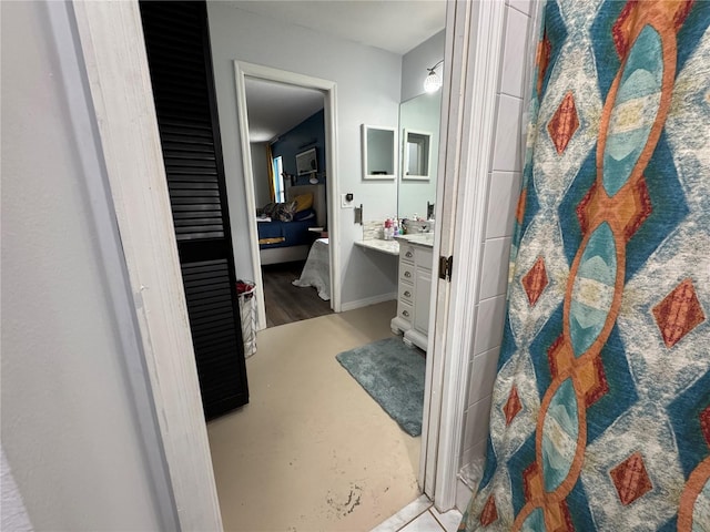 full bath with vanity, a shower, concrete floors, and ensuite bathroom