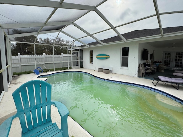 view of swimming pool with glass enclosure, fence, a patio area, and a fenced in pool