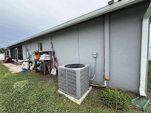 exterior space with stucco siding, cooling unit, and a sunroom