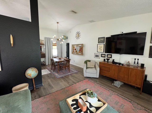 living area featuring vaulted ceiling, wood finished floors, visible vents, baseboards, and a chandelier