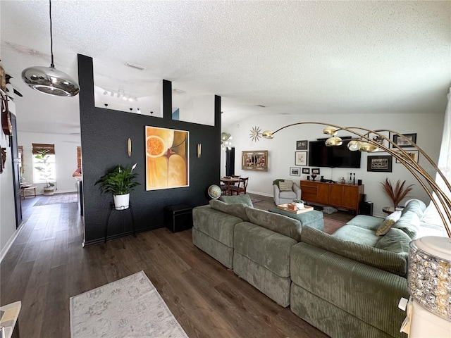 living room with lofted ceiling, wood finished floors, visible vents, a chandelier, and a textured ceiling