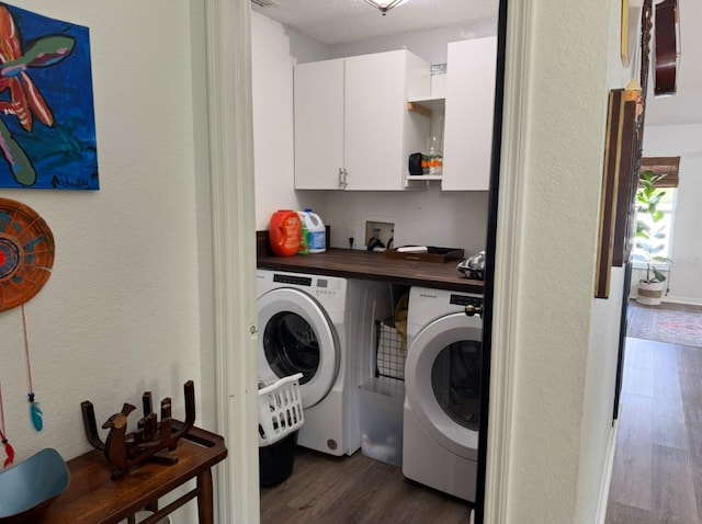 washroom with visible vents, washer and clothes dryer, cabinet space, and dark wood finished floors