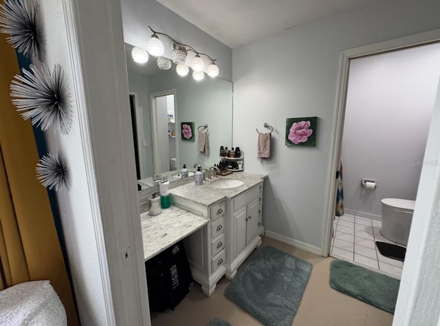 bathroom featuring baseboards, vanity, tile patterned floors, and toilet