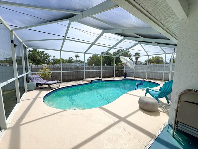 view of swimming pool featuring a patio area, a fenced backyard, a fenced in pool, and glass enclosure