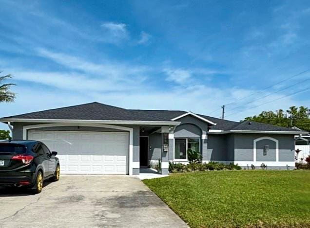 ranch-style house featuring an attached garage, driveway, a front lawn, and stucco siding