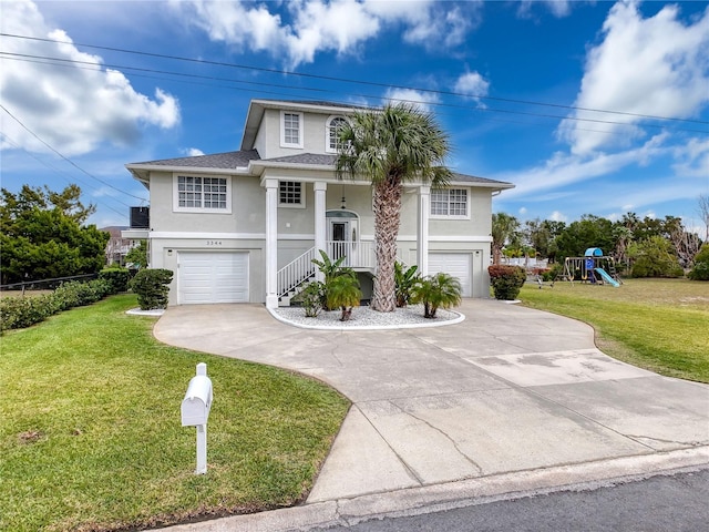 view of front of property featuring an attached garage, a front yard, a playground, and stucco siding