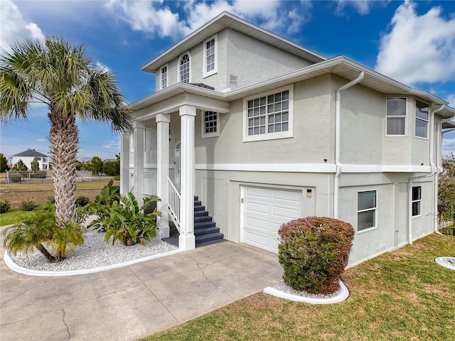 view of front of house with a garage, concrete driveway, and stucco siding