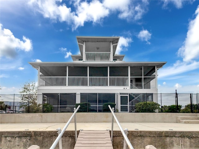 back of house featuring fence and a sunroom