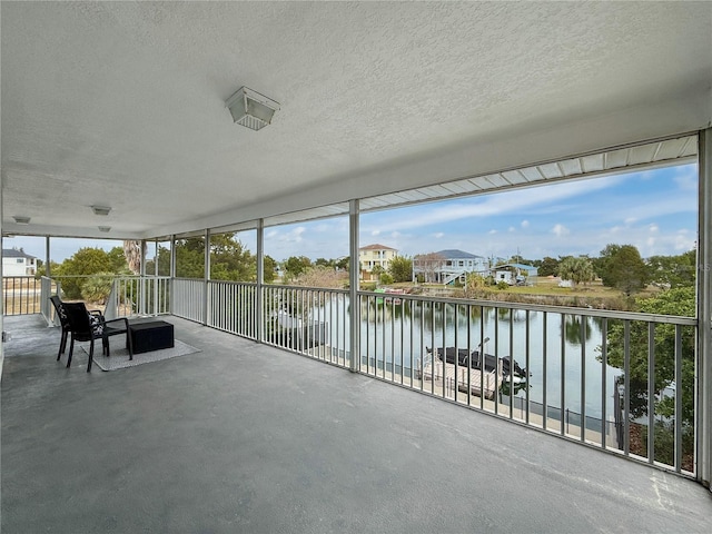 unfurnished sunroom featuring a water view