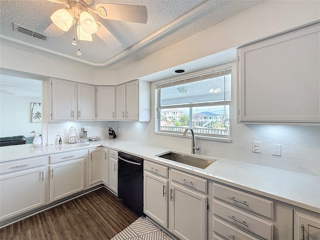 kitchen featuring black dishwasher, visible vents, dark wood-type flooring, light countertops, and a sink