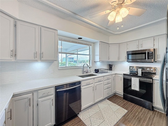 kitchen with a sink, white cabinets, stainless steel appliances, and light countertops