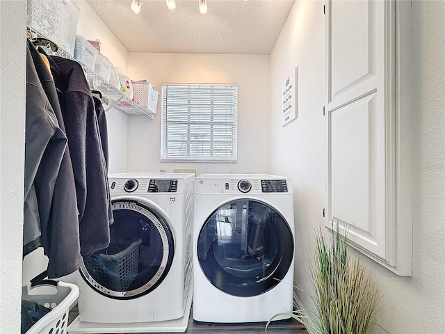 washroom featuring laundry area, a textured ceiling, and washer and dryer