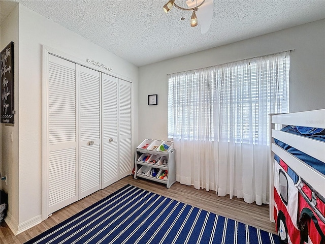 playroom with a textured ceiling and wood finished floors