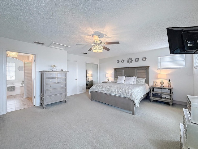 bedroom with light carpet, a textured ceiling, and visible vents