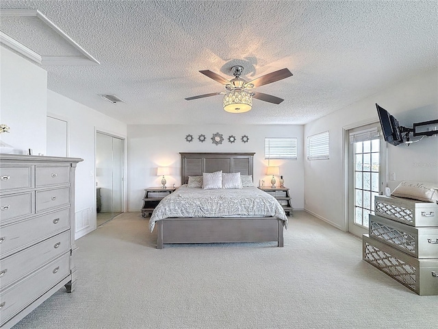 bedroom with visible vents, ceiling fan, light carpet, and a textured ceiling