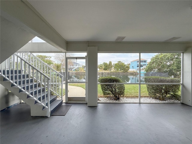 unfurnished sunroom featuring a water view