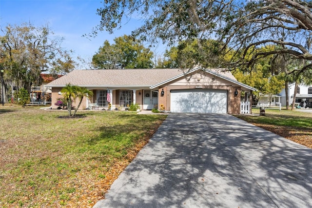 single story home with a garage, driveway, brick siding, and a front yard