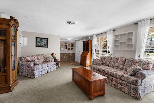 living area featuring light carpet and visible vents