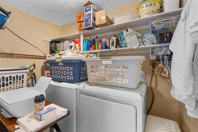 washroom with laundry area, a textured ceiling, and washing machine and clothes dryer