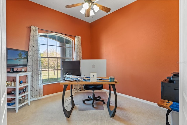 carpeted office space with baseboards and ceiling fan