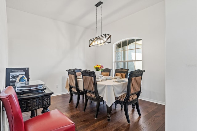 dining room featuring wood finished floors, baseboards, and a chandelier