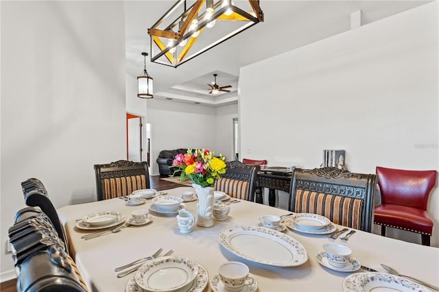 dining area with a tray ceiling and a ceiling fan