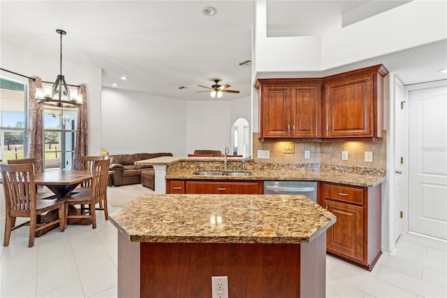 kitchen featuring a sink, decorative backsplash, brown cabinets, and stainless steel dishwasher