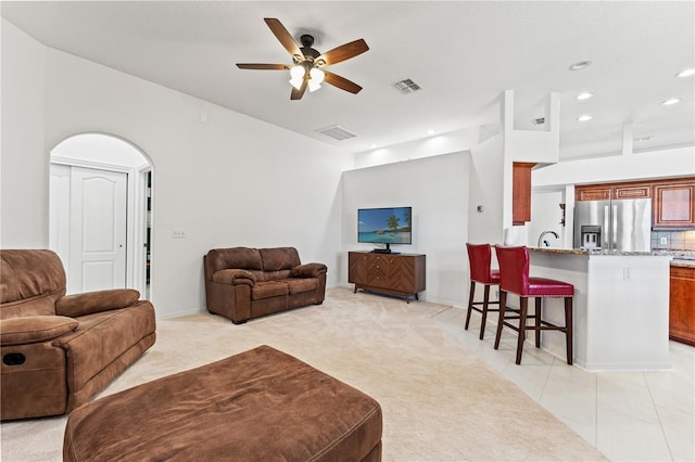 living room with a ceiling fan, recessed lighting, light colored carpet, and visible vents