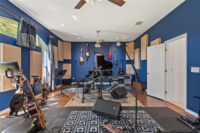 workout room featuring visible vents, baseboards, wood finished floors, and a ceiling fan