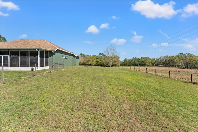 view of yard featuring fence and a sunroom