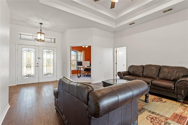 living room featuring french doors, visible vents, wood-type flooring, and ceiling fan