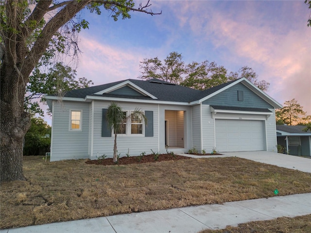 single story home with a garage, driveway, and a lawn