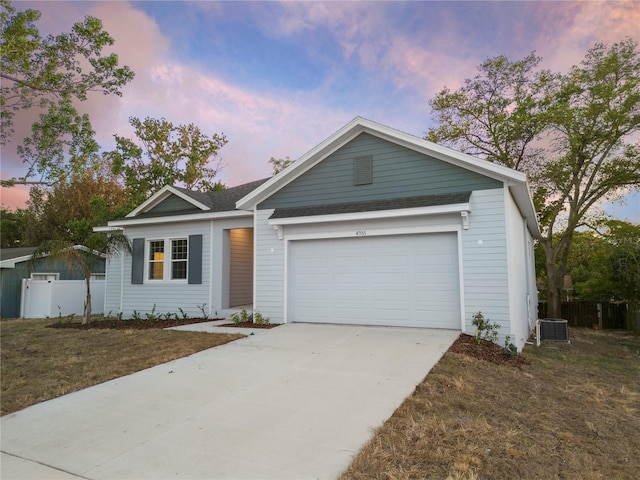 ranch-style house with an attached garage, driveway, a front yard, and fence