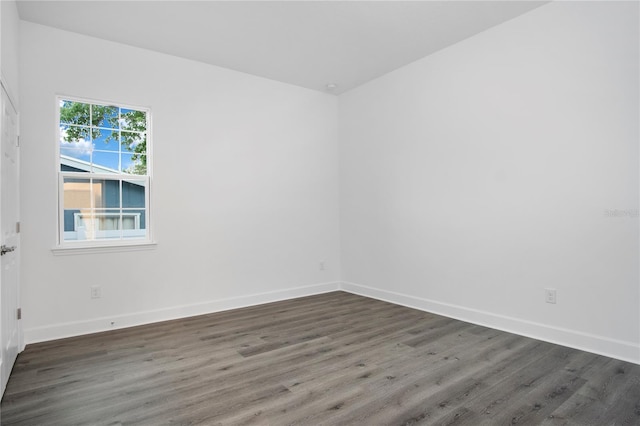 spare room with dark wood-style floors and baseboards