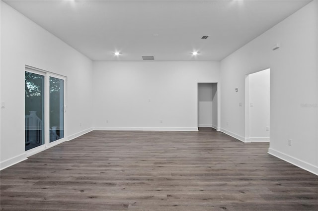 unfurnished room featuring dark wood-style floors, baseboards, and visible vents