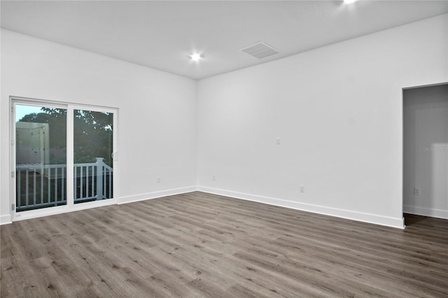 empty room featuring visible vents, baseboards, and wood finished floors