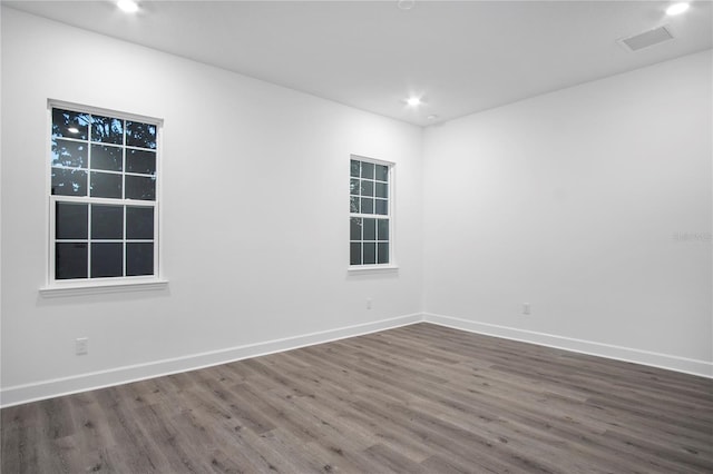 spare room featuring recessed lighting, visible vents, dark wood finished floors, and baseboards