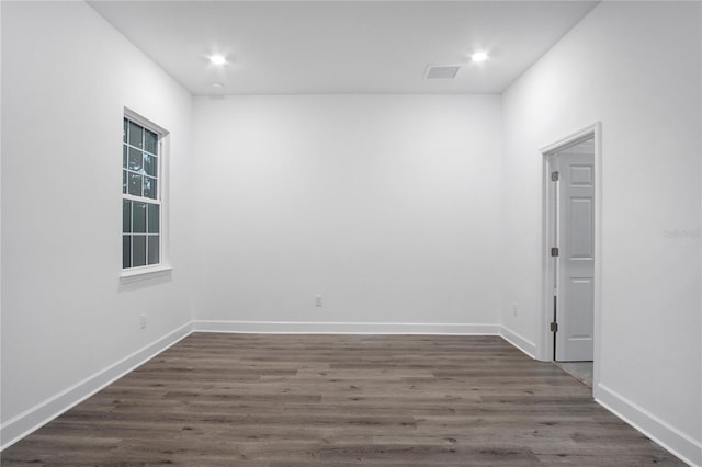 spare room featuring recessed lighting, dark wood-style flooring, visible vents, and baseboards